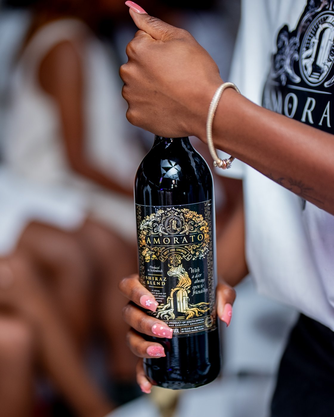 A hand holding a bottle of Amorato Kohwo Shiraz Blend