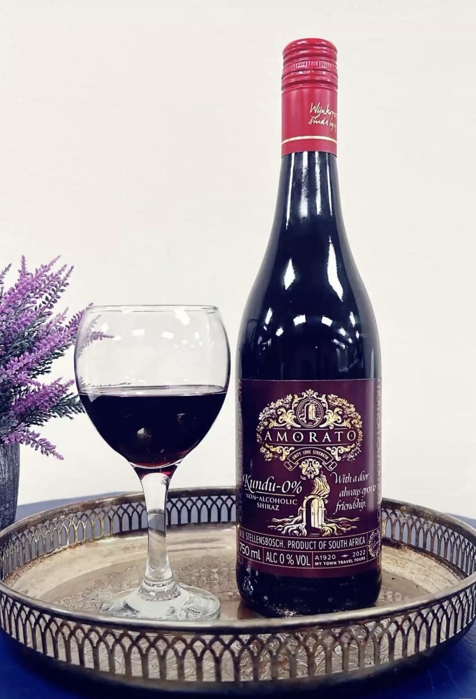 Amorato Kundu Non-Alcoholic Shiraz with a glass, styled among lavender