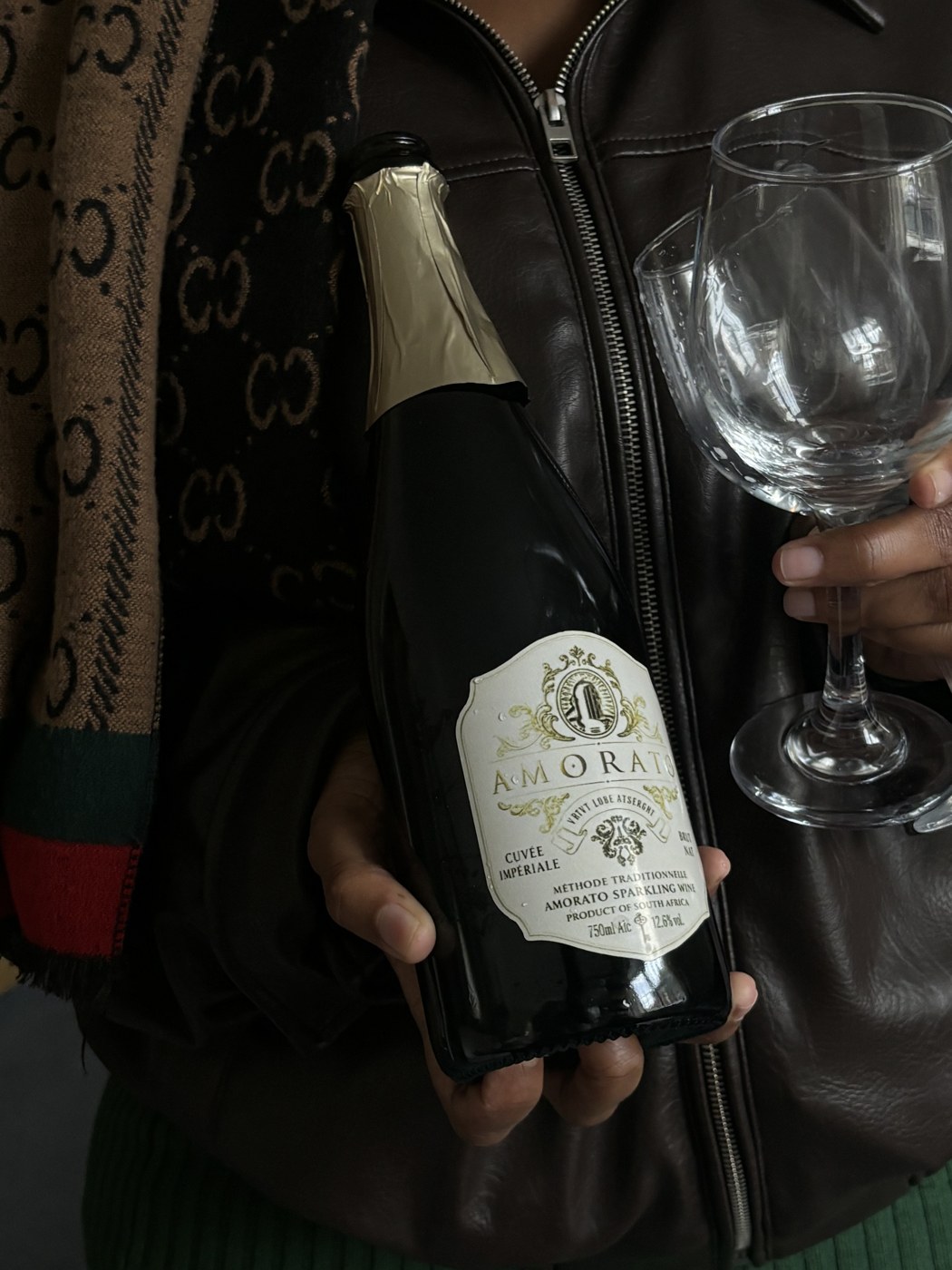 Amorato Cuvée Impériale sparkling wine bottle, held with a glass
